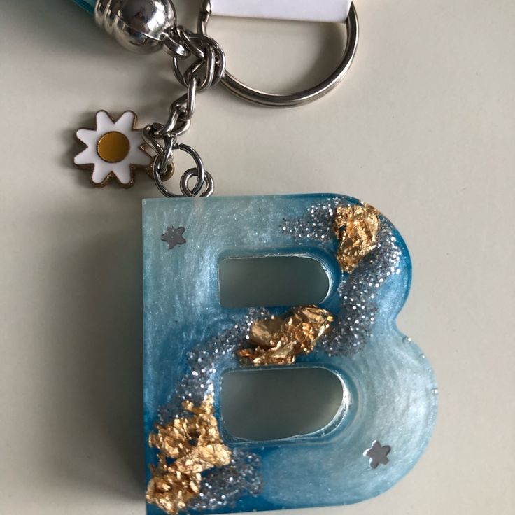 the letter b is made out of plastic and has gold leaf decorations on it's sides