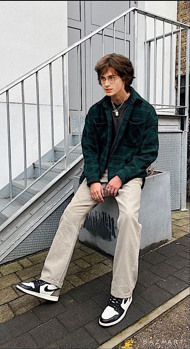 a young man sitting on top of a metal hand rail next to a stair case