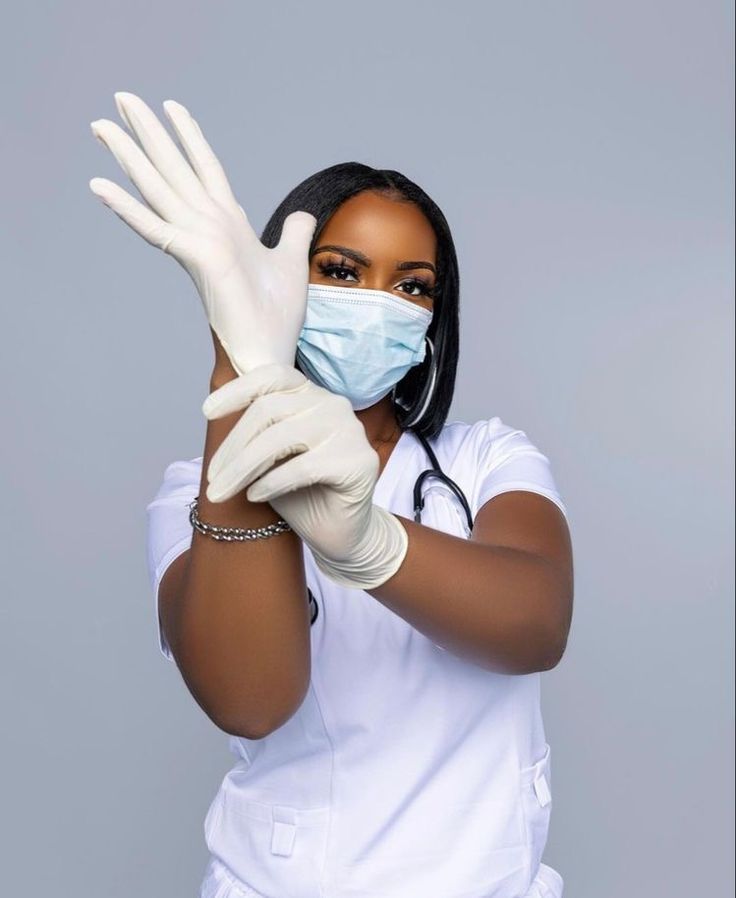 a woman wearing white gloves and a face mask holds her hands up to the camera