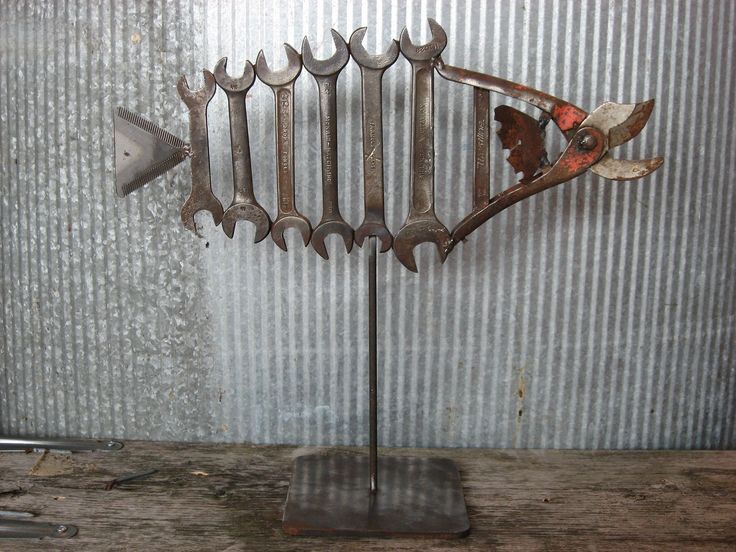 a metal fish sculpture sitting on top of a wooden table