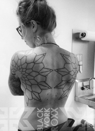 the back of a woman's body with geometric designs on her upper and lower half