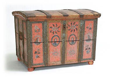 an old wooden chest with painted designs on the front and side panels, sitting against a white background