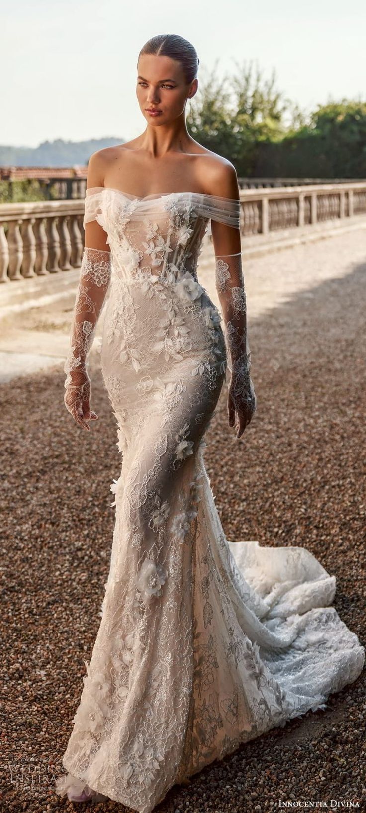 a woman in a wedding dress is standing on the ground with her hands behind her back