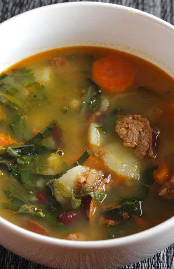 a white bowl filled with meat and vegetable soup