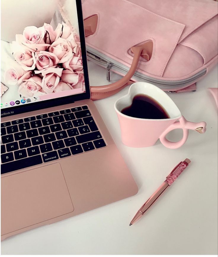 an open laptop computer sitting on top of a desk next to a cup of coffee