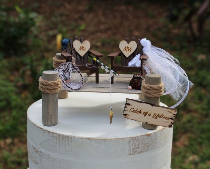 a wedding cake topper with two wooden hearts on the top and an umbrella in the middle