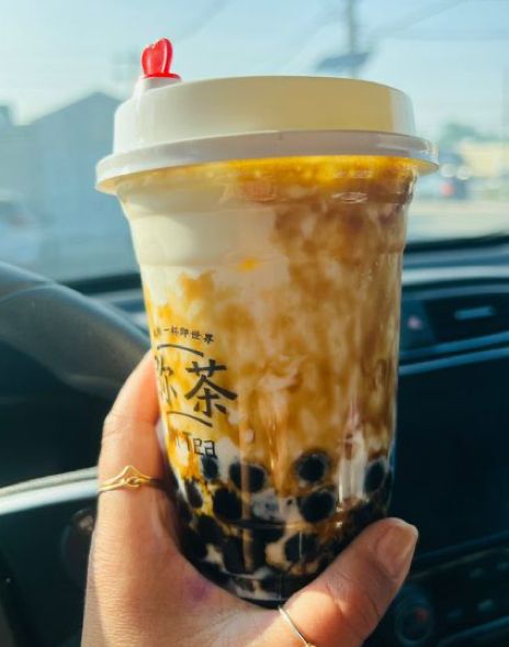 a person holding up a coffee cup in their hand with the lid down and writing on it