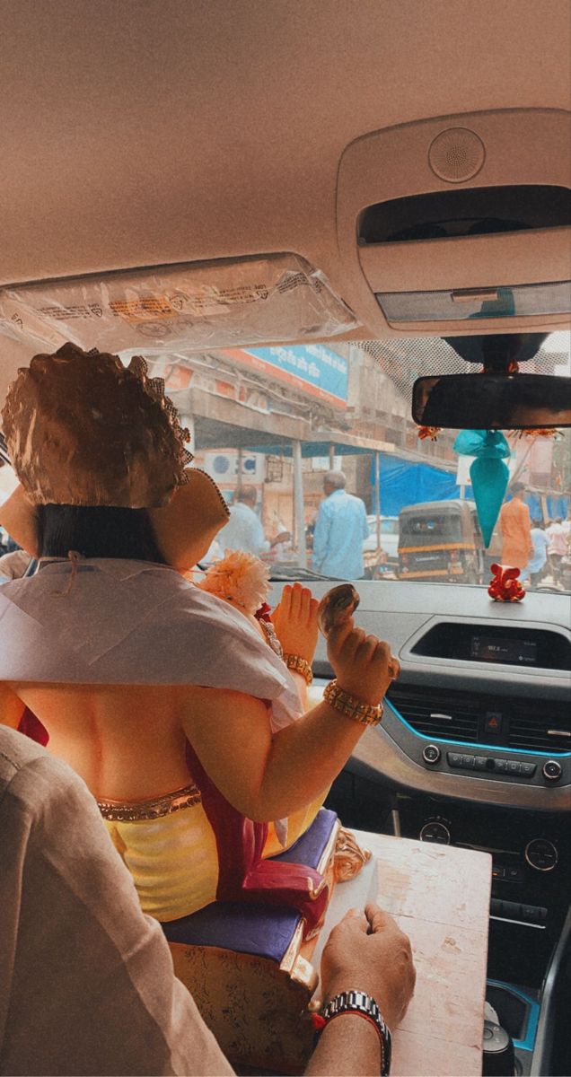 two people sitting in the back seat of a car