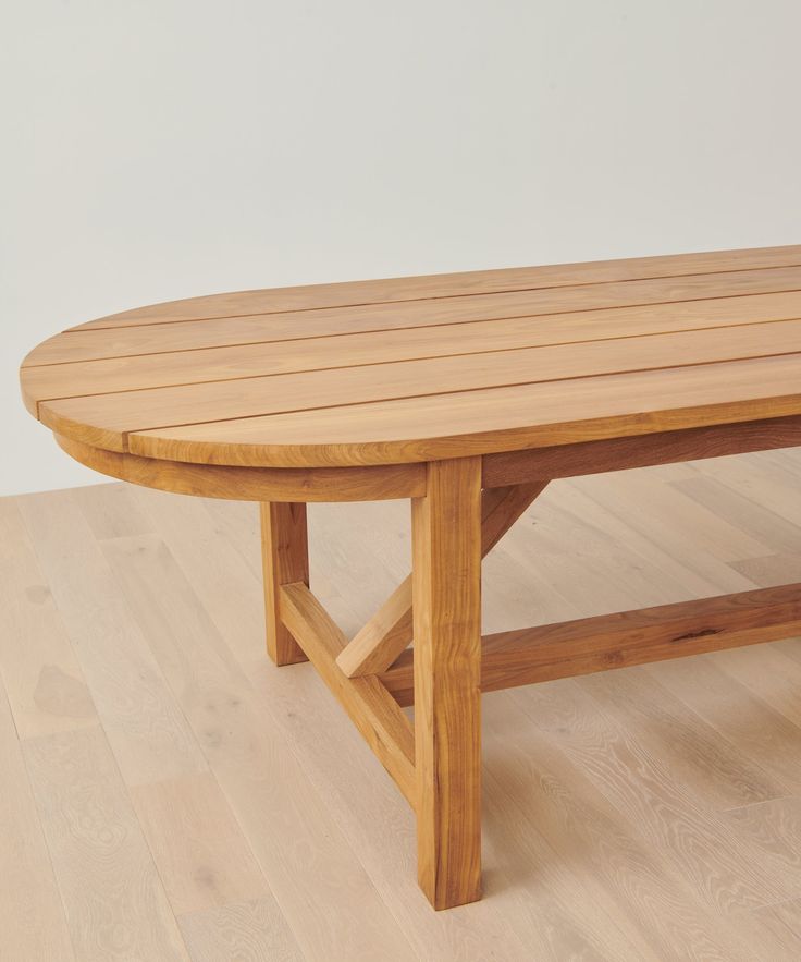 a wooden table sitting on top of a hard wood floor next to a white wall