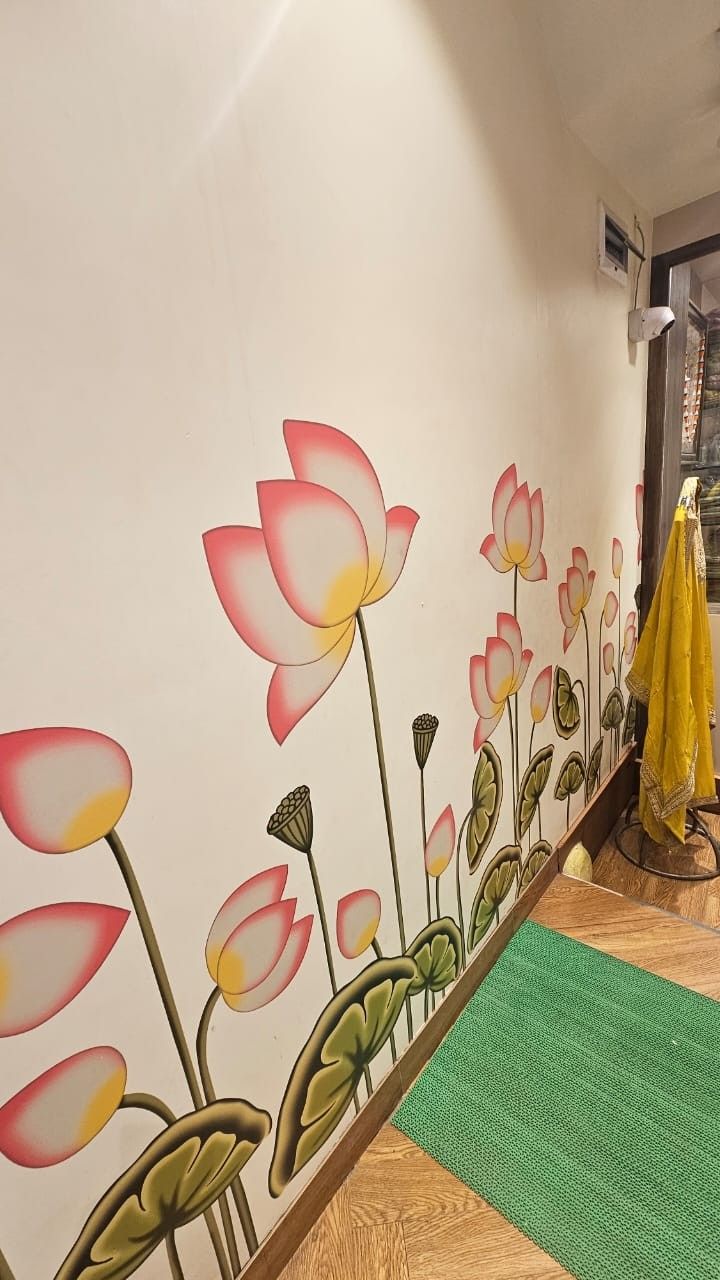 the wall has flowers painted on it and is next to a green rug with a yellow umbrella