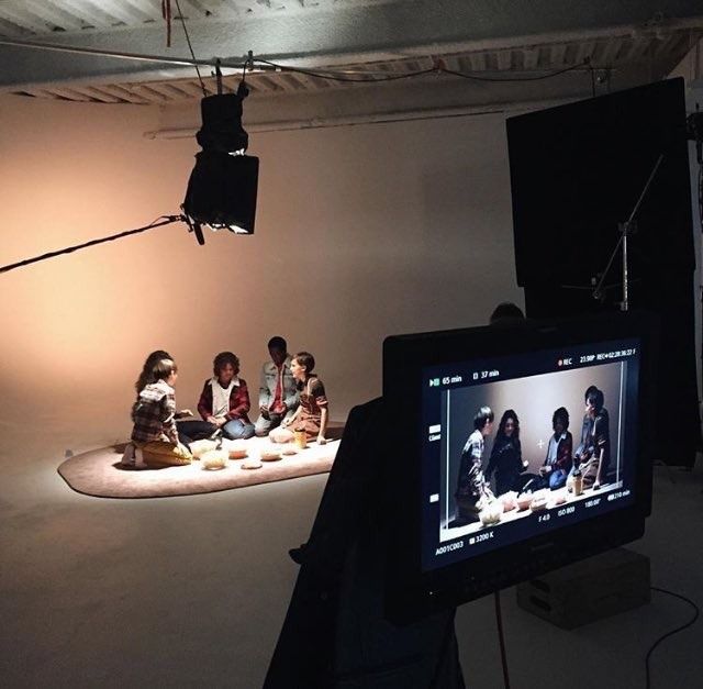 a group of people sitting on top of a floor in front of a tv screen