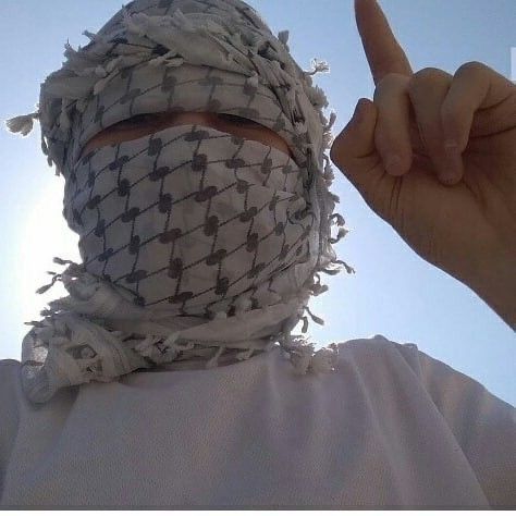 a person wearing a bandana and pointing to the sky