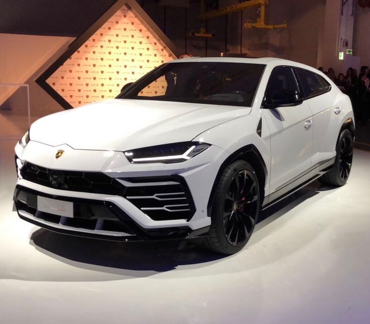 a white lamb suv is on display at an auto show