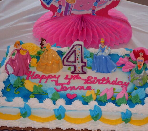 a birthday cake with the number four on it and princesses in pink, green, yellow and blue frosting