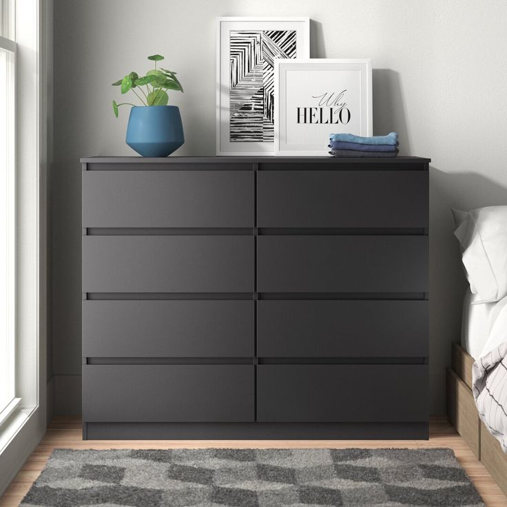 a bedroom with a bed, dresser and pictures on the wall next to each other