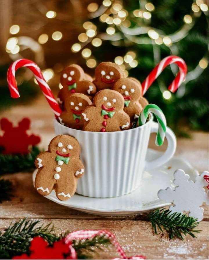 a cup filled with cookies and candy canes