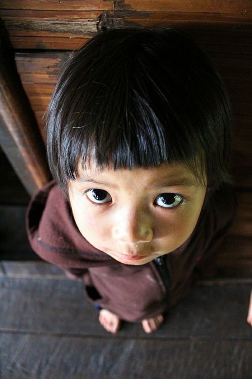 a young boy is looking up at the camera