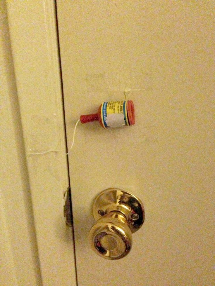 an open door with a toothbrush on the handle and a tube of toothpaste