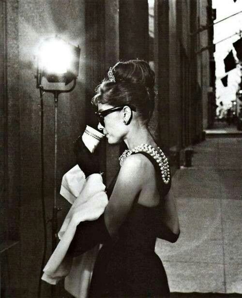 a black and white photo of a woman talking on a cell phone while walking down the street