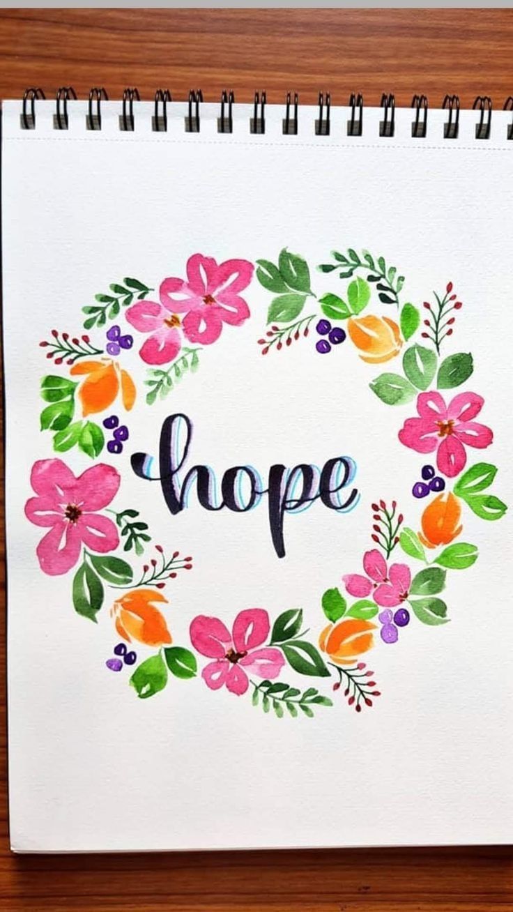 a spiral notebook with watercolor flowers and the word hope written in it on top