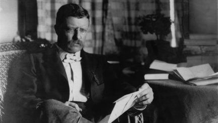 an old photo of a man sitting in a chair