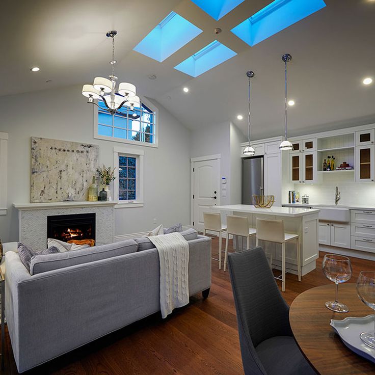 a living room filled with furniture and a fire place in the middle of a kitchen