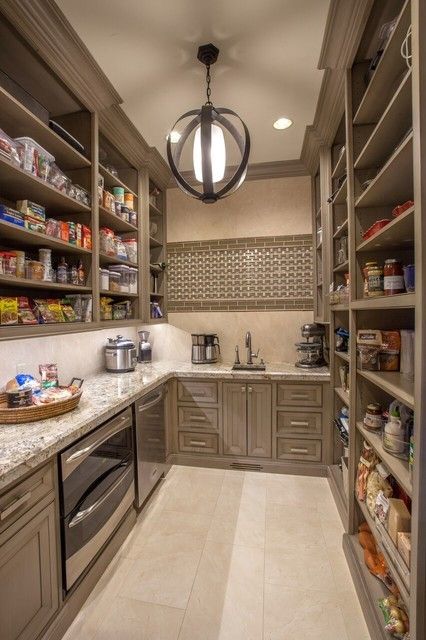 a kitchen filled with lots of counter top space next to a light hanging from the ceiling