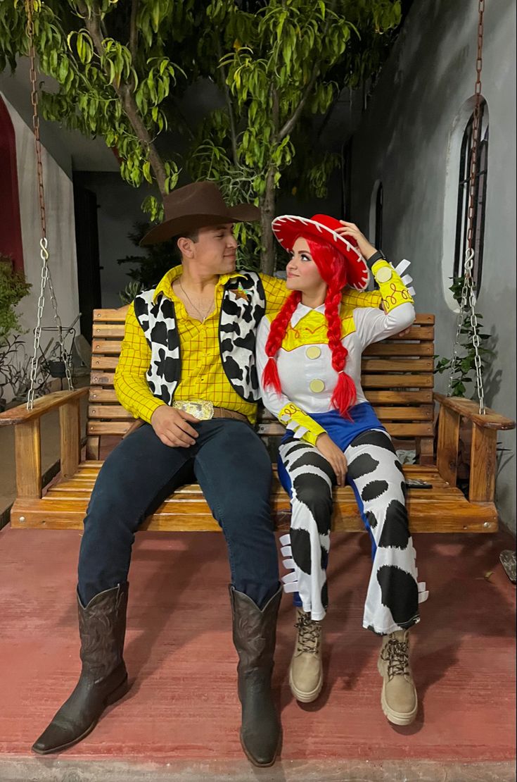 a man and woman sitting on a bench dressed as toy story characters, one is wearing a cowgirl costume