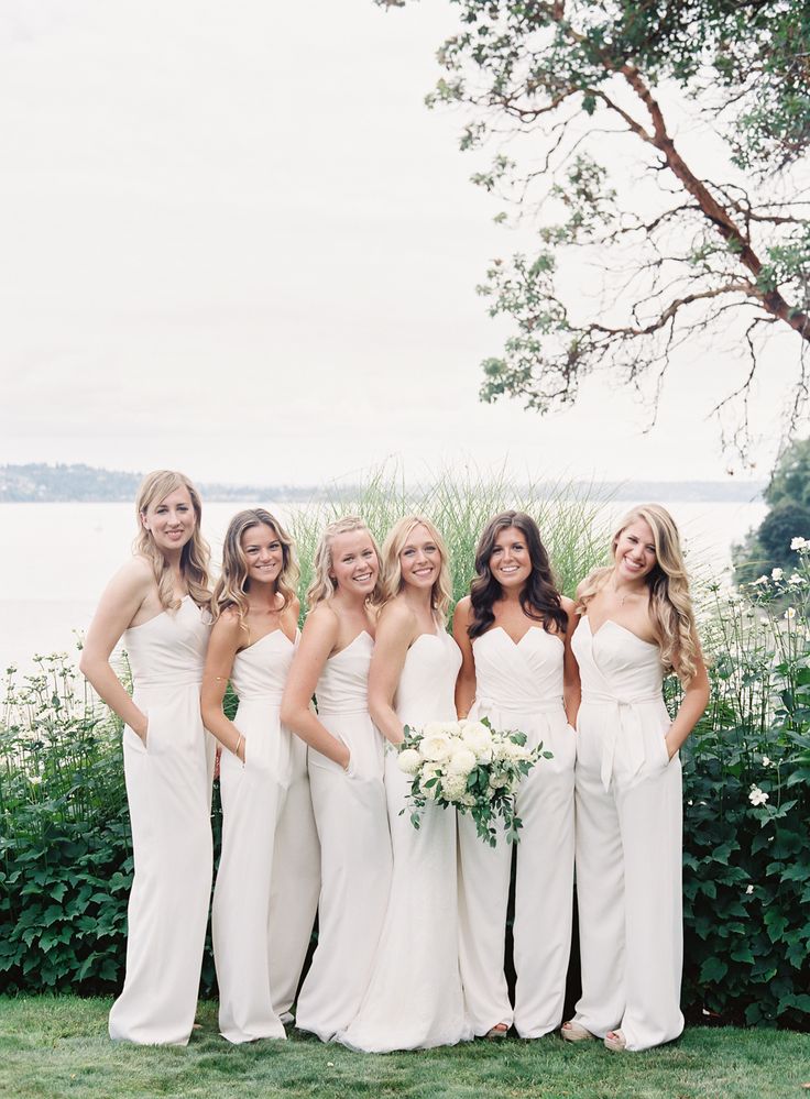 a group of women standing next to each other on top of a lush green field