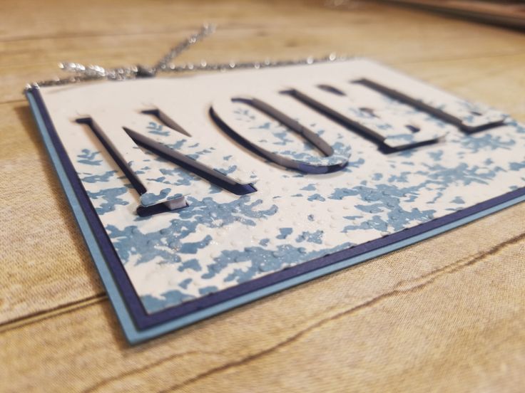 a close up of a metal sign on a wooden table with chains hanging from it