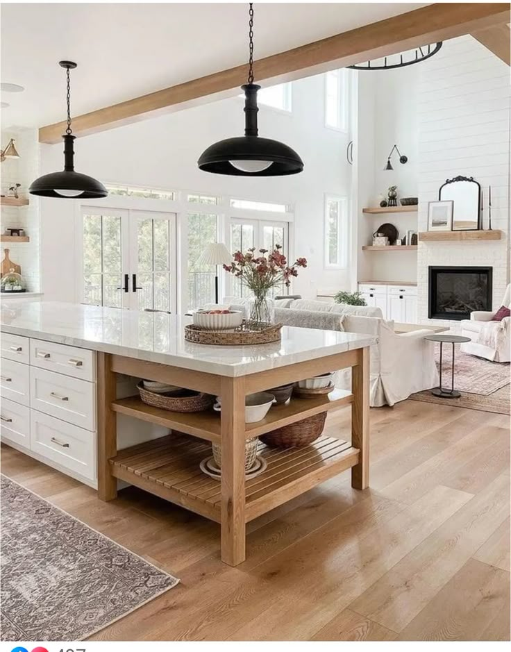 a large kitchen with an island in the center and two pendant lights hanging from the ceiling