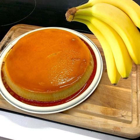 a bowl of sauce and some bananas on a cutting board