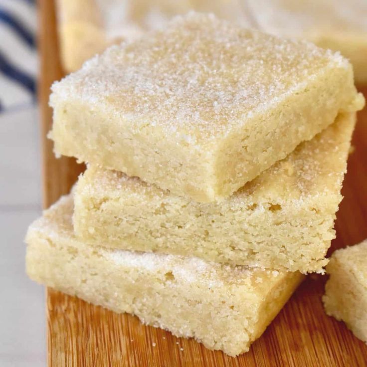 three pieces of cake sitting on top of a wooden cutting board