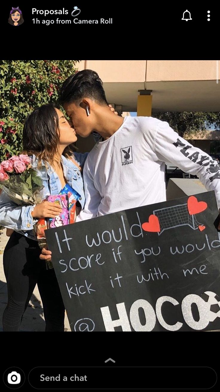 a man and woman kissing in front of a sign that says it would scare if you would kick it with me