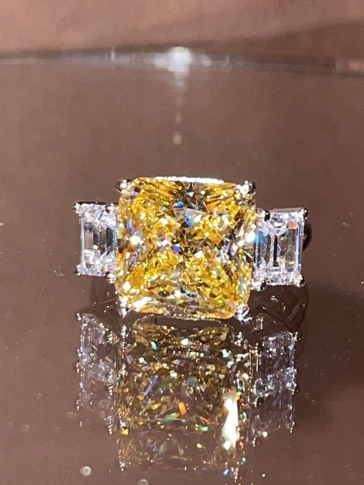 a fancy yellow diamond ring sitting on top of a table