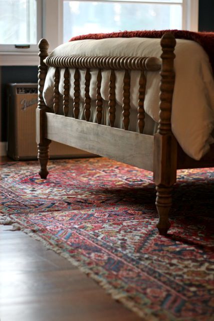 a bed sitting on top of a rug in a bedroom next to a fire place