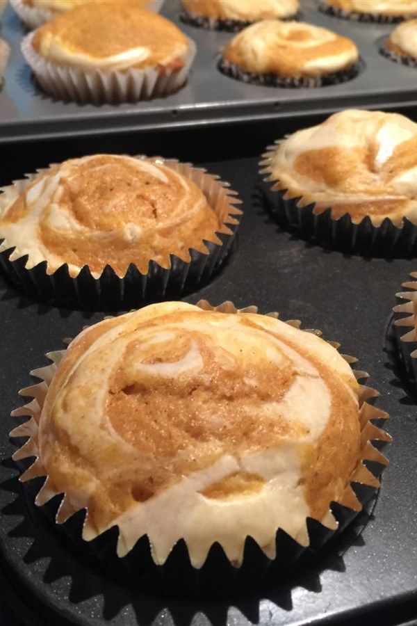 several cupcakes with frosting sitting in a muffin tin