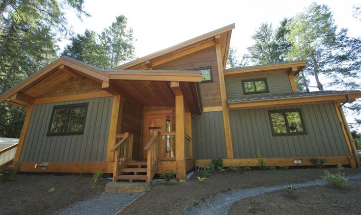 a house that is made out of wood and has stairs leading up to the front door