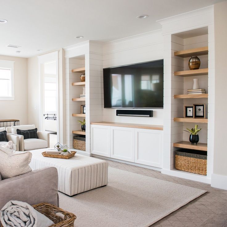 a living room filled with furniture and a flat screen tv mounted on the wall above it