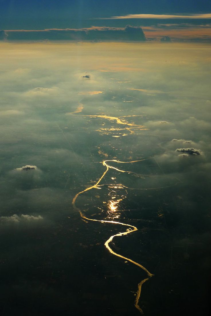 the view from an airplane looking down at clouds and water with light trails on them