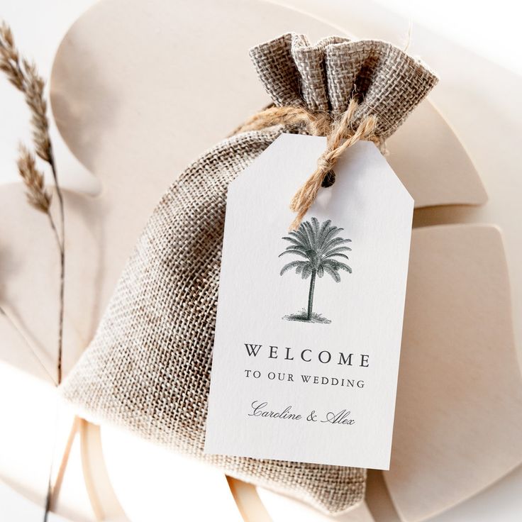 a welcome gift bag with a palm tree tag attached to the front and back of it