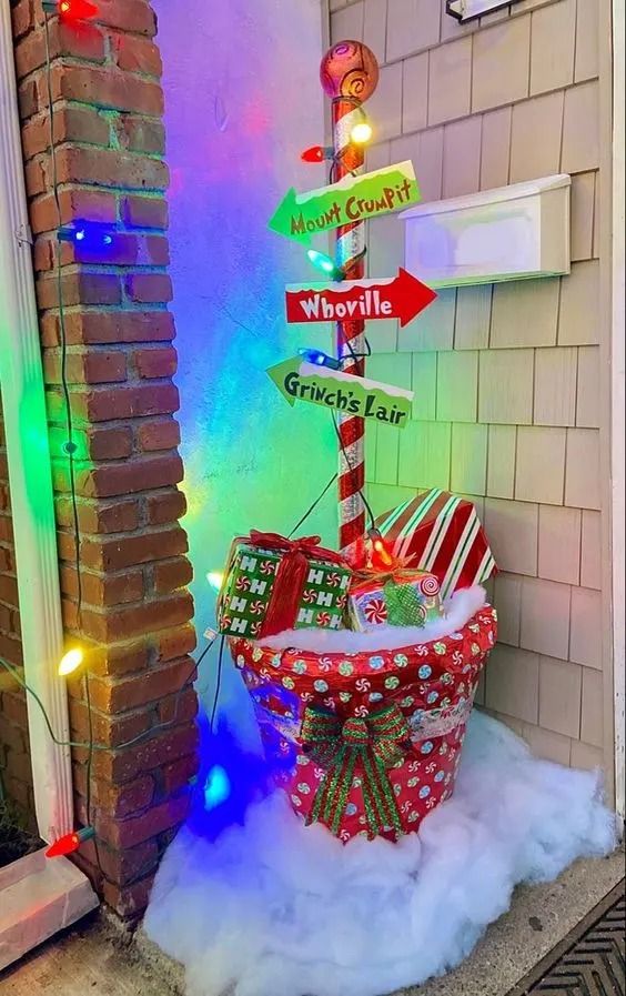 a basket filled with presents sitting in front of a door decorated for the holiday season