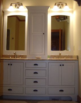 a bathroom with double sinks and two large mirrors on the wall above it is illuminated by three lights