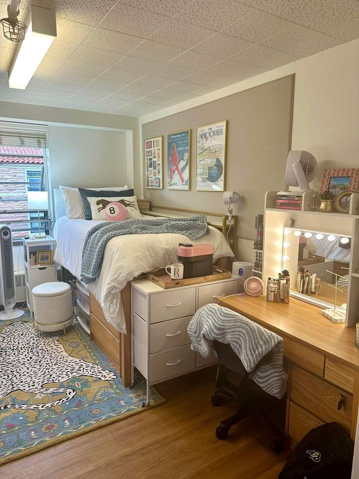 a bedroom with a bed, desk and dresser in it's corner area next to a window