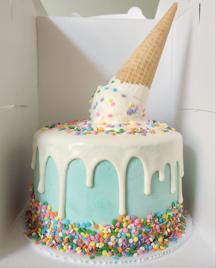 a birthday cake with sprinkles and an ice cream cone on top