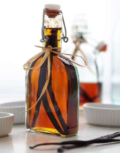 a glass bottle filled with liquid sitting on top of a table next to utensils