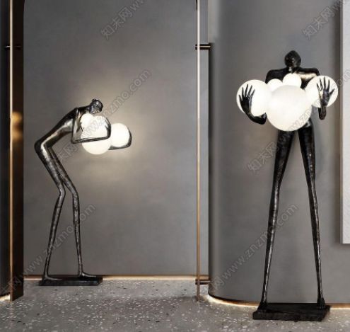 a couple of sculptures sitting next to each other in front of a wall mounted light