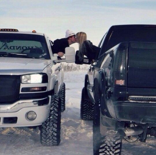 two people sitting in the bed of a pickup truck with four tires on it's flatbed