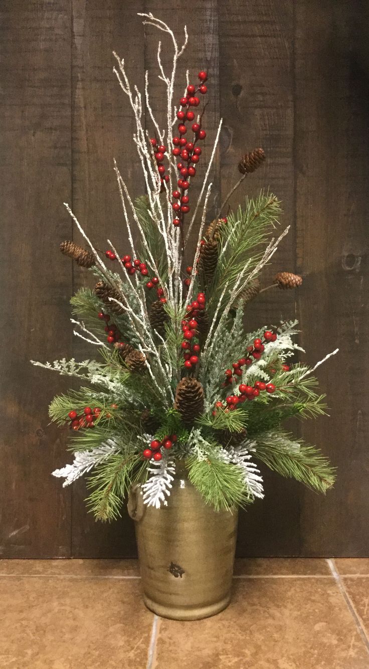 a potted plant with red berries and pine cones