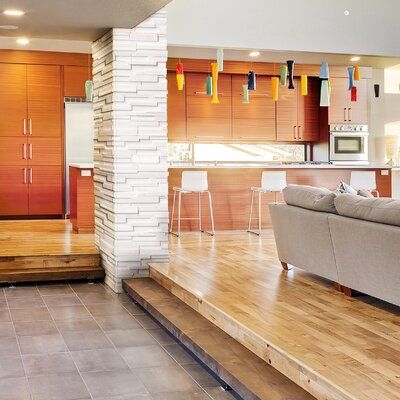 a living room filled with furniture next to a kitchen